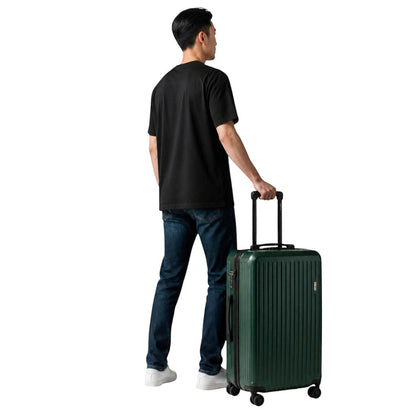 Homme debout tenant une valise de cabine rigide vert forêt MoveLite avec poignée télescopique sur fond gris